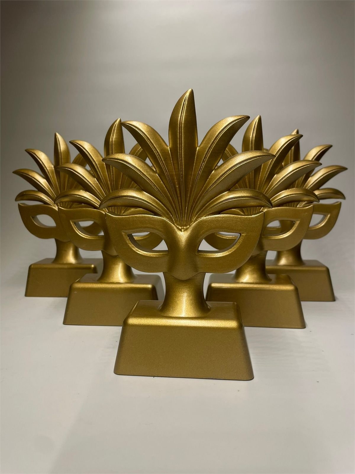 A series of gold 3D printed carnival mask awards