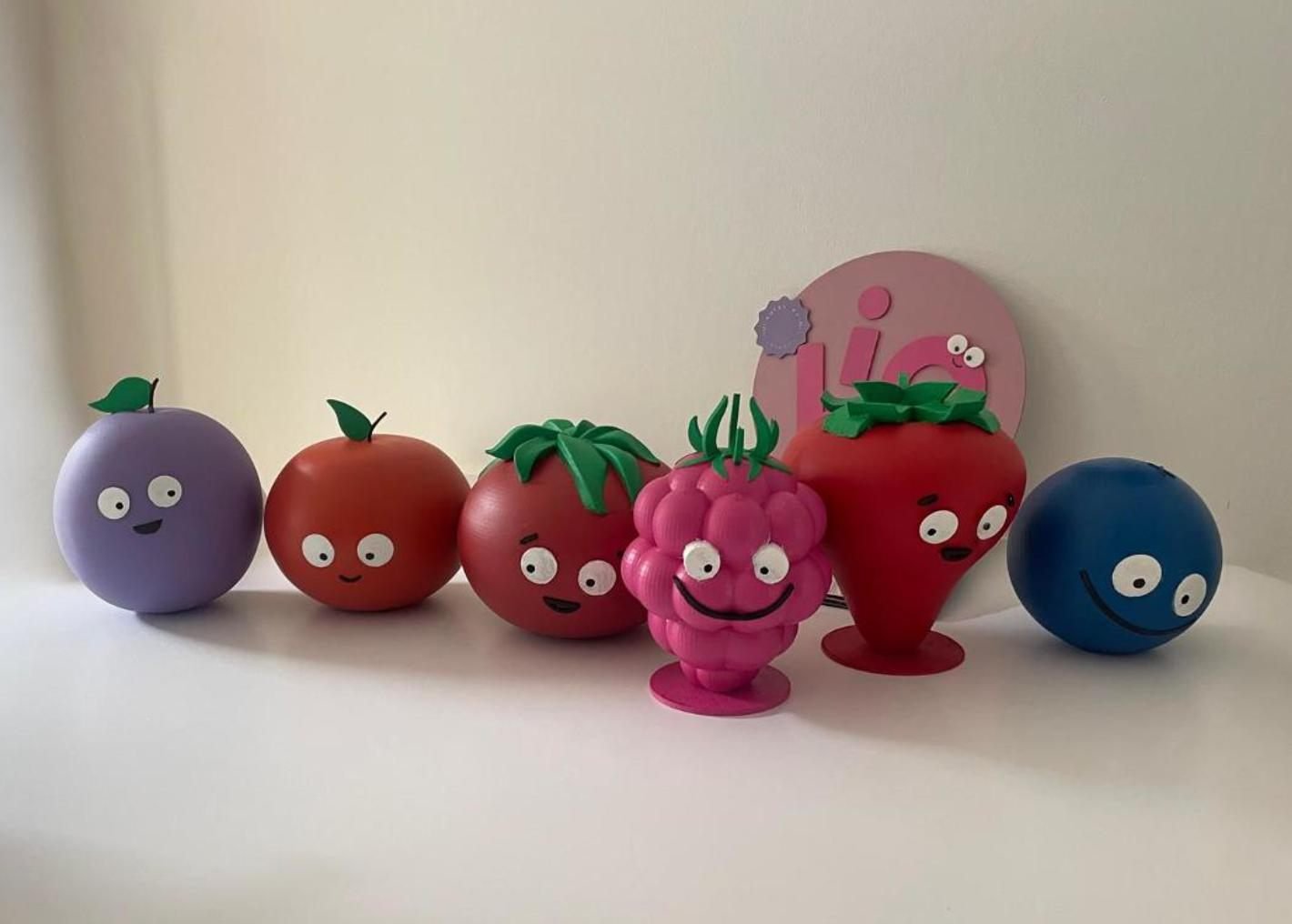 3D printed and painted fruit characters with a layered acrylic logo sign