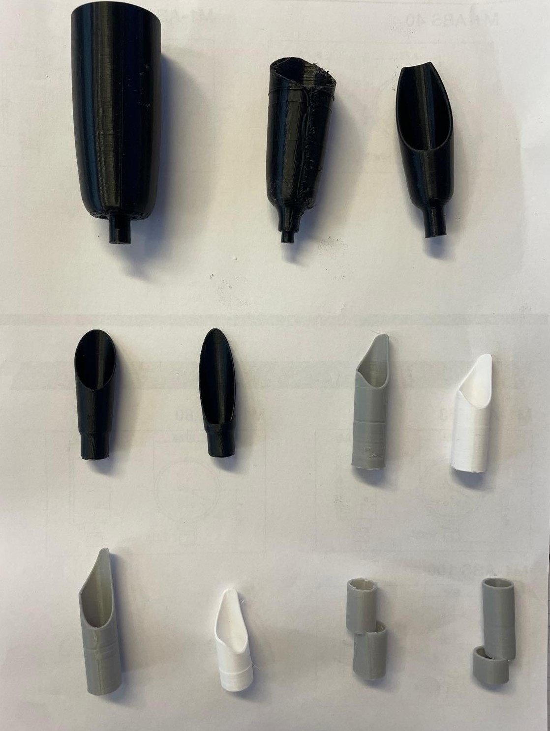 A row of 3D printed prototype iterations, from first to latest
