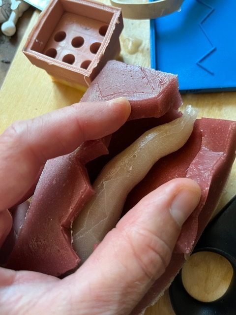 A cast part being taken out of a silicone mould